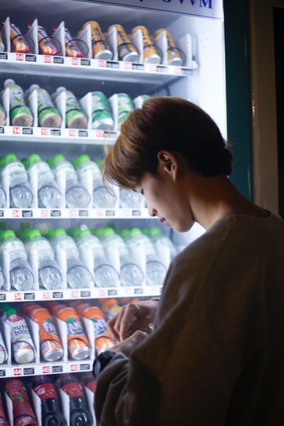 Woman wearing a brown shirt and holding a white plastic bottles
